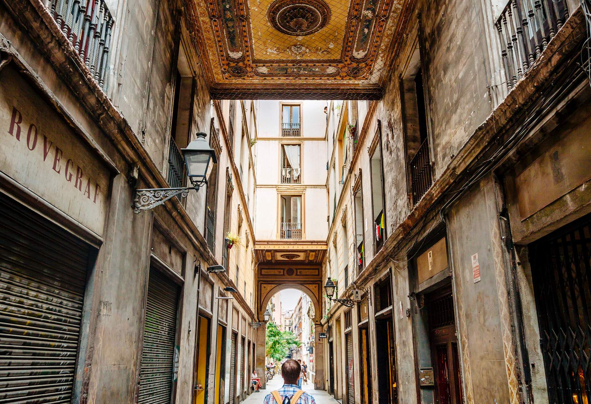 Tourist with backpack bag wandering through the narrow street of Gothic Quarter in Barcelona, Catalonia, Spain